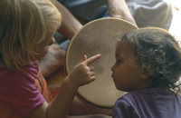 Zwei Kinder spielen mit der Trommel